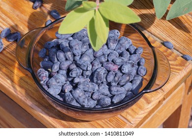 A Wooden Tray Filled With Freshly Harvested Fruits. Kamchatka Berries (honeyberry). 