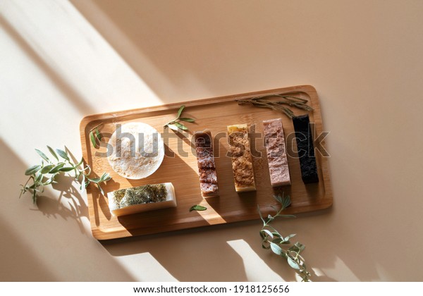 Wooden tray with handmade soap from natural\
ingredients. Warm background with highlights from the sun on the\
theme of natural\
cosmetics.