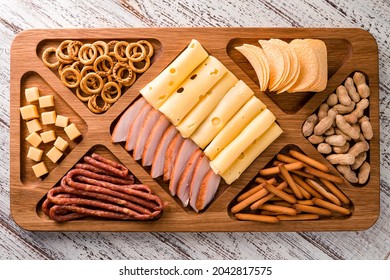 Wooden Tray With Meat And Cheese, Antipasto Snacks. Antipasto Cold Meat Dish With Breadsticks, Prosciutto, Ham, Ham Slices And Cheese On A Wooden Tray Top View, Flat Lay