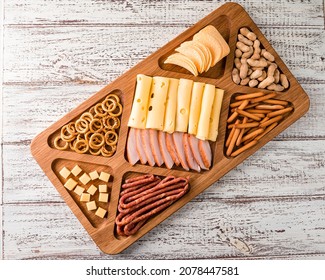 Wooden Tray With Meat And Cheese, Antipasto Snacks. Antipasto Cold Meat Dish With Breadsticks, Prosciutto, Ham, Ham Slices And Cheese On A Wooden Tray Top View, Flat Lay