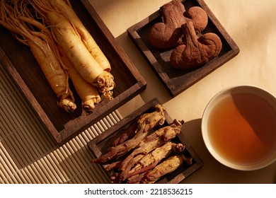 A wooden trays with bowls of medication, ginseng, red ginseng and reishi mushrooms. Traditional medicine. - Shutterstock ID 2218536215