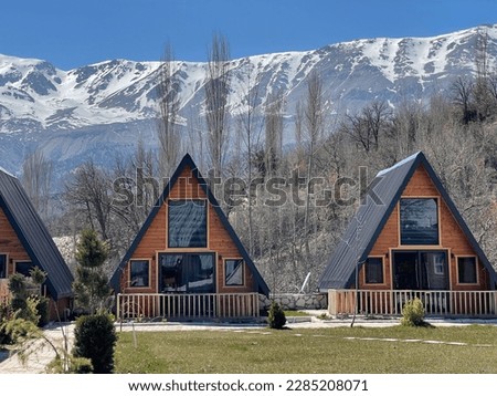Wooden triangle chalets wonderful panoramic landscape Snow on the tops of mountains Snow natural houses different perspective angles interesting background images Tourism travel sightseeing vacation.