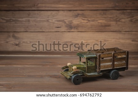 Wooden truck over retro vintage brown background. Wooden retro car model. Educational toys for preschool and kindergarten child. Toys from wood.