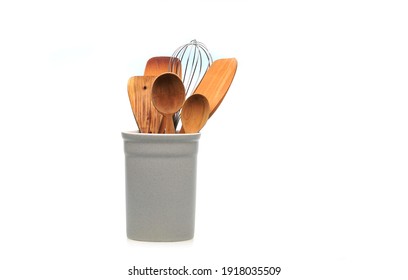 Wooden utensils for cooking are in a white glass. Kitchen spoons, scoops, forks isolated on white background. Scandinavian style in the interior of the kitchen. - Shutterstock ID 1918035509