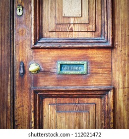 A Wooden Vintage Front Door With A Letter Box