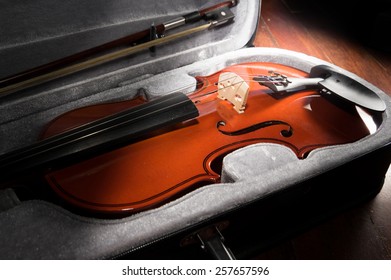 Wooden violin in black case.