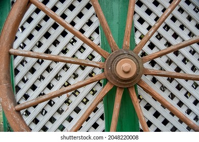 wooden wagon wheel against fence
