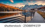 Wooden walkway in Misurina village, Italy, Europe. Picturesque autumn sunset on Misurina lake. Wonderful morning scene of Dolomite Alps. Traveling concept background.