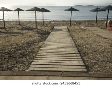 wooden walkway and umbrellas on the summer beachat morning - Powered by Shutterstock