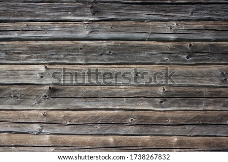 Wooden wall with gray and brown bars. Texture old wood is used in a design, furniture making and construction. Wood is trendy. Dry wood. Wood is a common material in a construction. Old bars with crac
