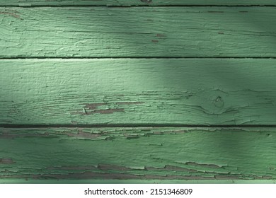 Wooden wall of a house made of old peeling pine boards painted with green paint, may be used as background 