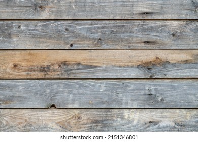 Wooden wall of a house made of unpainted old gray pine planks