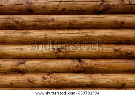 Wooden wall from logs of pine as a background texture. 