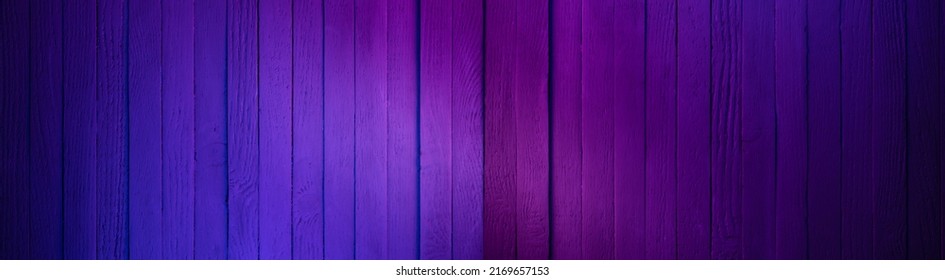 Wooden wall painted in Cyan and Magenta colors. Dark surface with neon colors