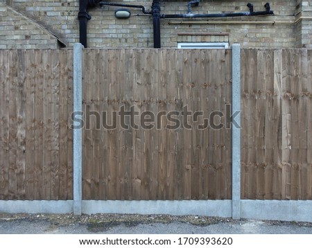 Wooden wall in the street with bricks in the background