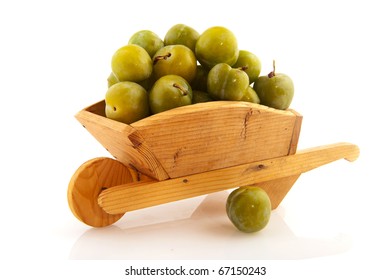 Wooden Wheel Barrow Full With Green Plums