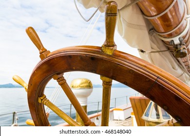 Wooden Wheel Of A Big Sailboat At Sea. Close Up Nautical Detail