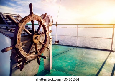 Wooden wheel on the ship at sunset on Issyk Kul lake 