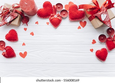 Wooden white background with red hearts, gifts and candles. The concept of Valentine Day. - Shutterstock ID 556008169