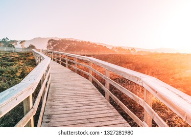 Wooden white bright color walking path with hand rails nature with fields forest and ocean sunrise sunset orange sun light and sky Romantic mystical in beach of cathedrals as catedrais Spain, Galicia - Powered by Shutterstock