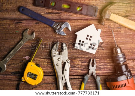 Wooden white house toy and construction tools on wooden background with copy space.Real estate concept, New house concept, Finance loan business concept, Repair maintenance concept Сток-фото © 