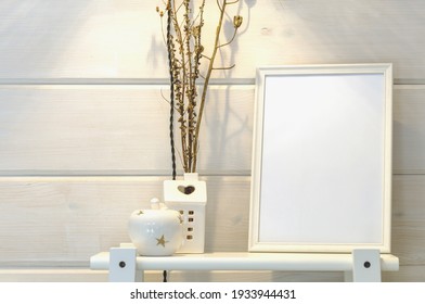 Wooden White Wall In A Scandinavian House, Mockup Of A White Photo Frame On A Shelf, Dry Flowers.