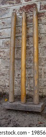 A Wooden Wicket Leaning Against A Brick Wall