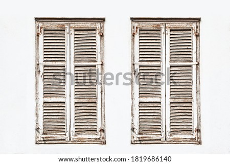 Wooden window shutter. White paint wall. Closed window isolated. European style architecture background. Two windows isolated on white.