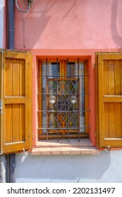 Wooden Window With Shutters Of The Bar With Wine Glasses. Red Building Exterior