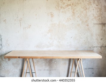 Wooden Workshop Table Against Concrete Wall.