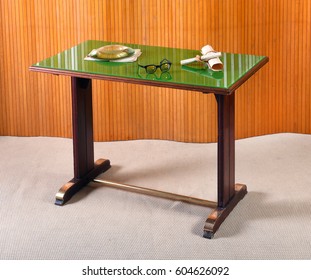 Wooden writing desk or escritoire with reflective green top surface displaying spectacles and rolled documents - Shutterstock ID 604626092