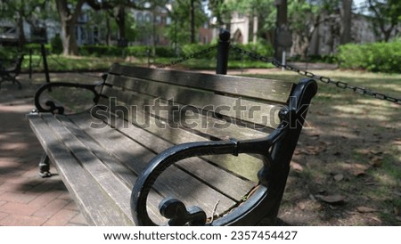 Wooden and wrought iron bench in savannah park : chippewa square. Isolated seat in an urban park with nobody. On a spring day. Georgia. 