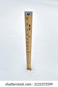 A wooden yardstick placed in the snow measuring nineteen inches of snowfall.