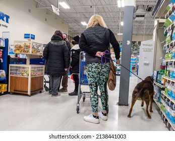 Woodinville, WA USA - circa February 2022: View of several people and a woman with her dog waiting in the checkout lines inside of a Petsmart store.