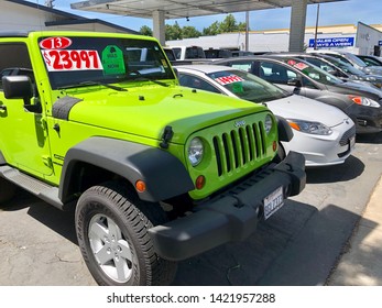 Woodland, CA - June 10, 2019: Used car dealership outside lot with sale discount tags on used American automobiles. 