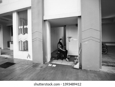 Woodlands / Singapore - May 10th 2019: A Cleaner Is Taking A Rest At The Void Deck.