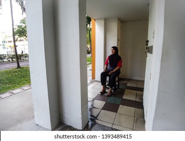 Woodlands / Singapore - May 10th 2019: A Cleaner Is Taking A Rest At The Void Deck.