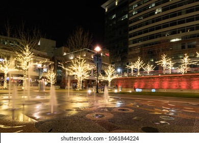 The Woodlands, Texas / United States of America - March 10 2018: The Woodlands Waterway. Fountain wall lit with red lights and surrounded by Christmas lights.