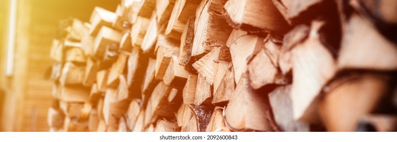 a woodpile with harvesting and stacked firewood of chopped wood for kindling and heating the house. firewood of the birch tree. banner.. flare
