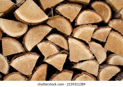 Woodpile lies in a heap, chopped for burning in a furnace. Finely chopped and stacked firewood, background. Laid dry firewood, texture, background. Firewood wall, dry chopped firewood background.