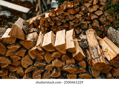 Woodpile stacked in front of larger woodpile with smaller woodpile on top