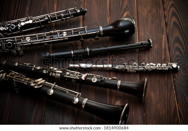 Woodwind instruments\
lie on a wooden\
surface