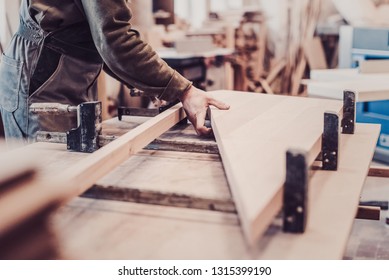 Woodwork and furniture making concept. Carpenter in the workshop marks out and assembles parts of the furniture cabinet close up
