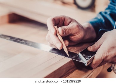 Woodwork and furniture making concept. Carpenter in the workshop marks out the details of the furniture cabinet using a setsquare close up - Powered by Shutterstock