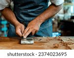 A woodworker is shown sharpening a chisel on a whetstone. The footage captures the essential steps of the sharpening process, and is ideal for use in educational or instructional materials.