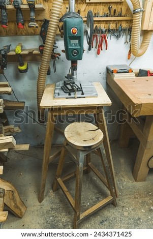 Woodworking mortise machine on a table, wooden furniture inside carpenter workplace. High quality photo
