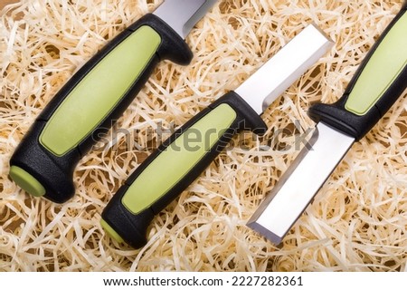 Woodworking tool. Carpentry tool. Sharp chisel and wood shavings. Wood cutting tool. Knife chisel in three angles. View from above.
