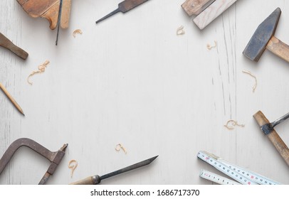 Woodworking tools on a white wooden table composition. Copy space in the middle. Top view, flat lay