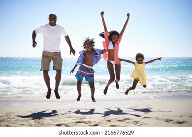 Woohoo Vacation time rocks. An excited african american family jumping into the air on the beach with a beautiful ocean in the background. - Powered by Shutterstock