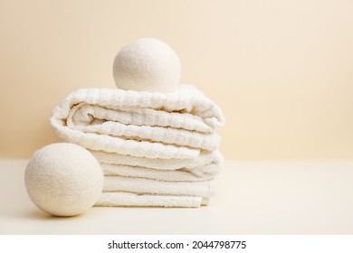 Wool Dryer Balls On White Towel On Beige Background. Eco Friendly Laundry Supplies. Alternative Drying Of Linen. Still Life. Text Space
